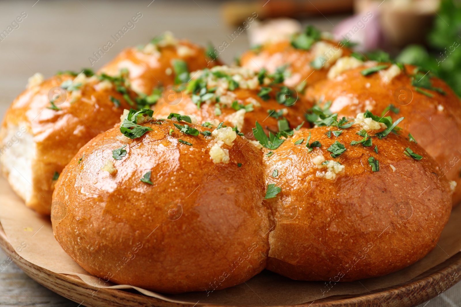 Photo of Traditional Ukrainian garlic bread (Pampushky) on wooden table, closeup