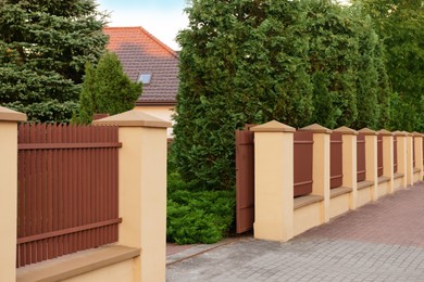 Photo of Open gates and beautiful fence with iron railing outdoors