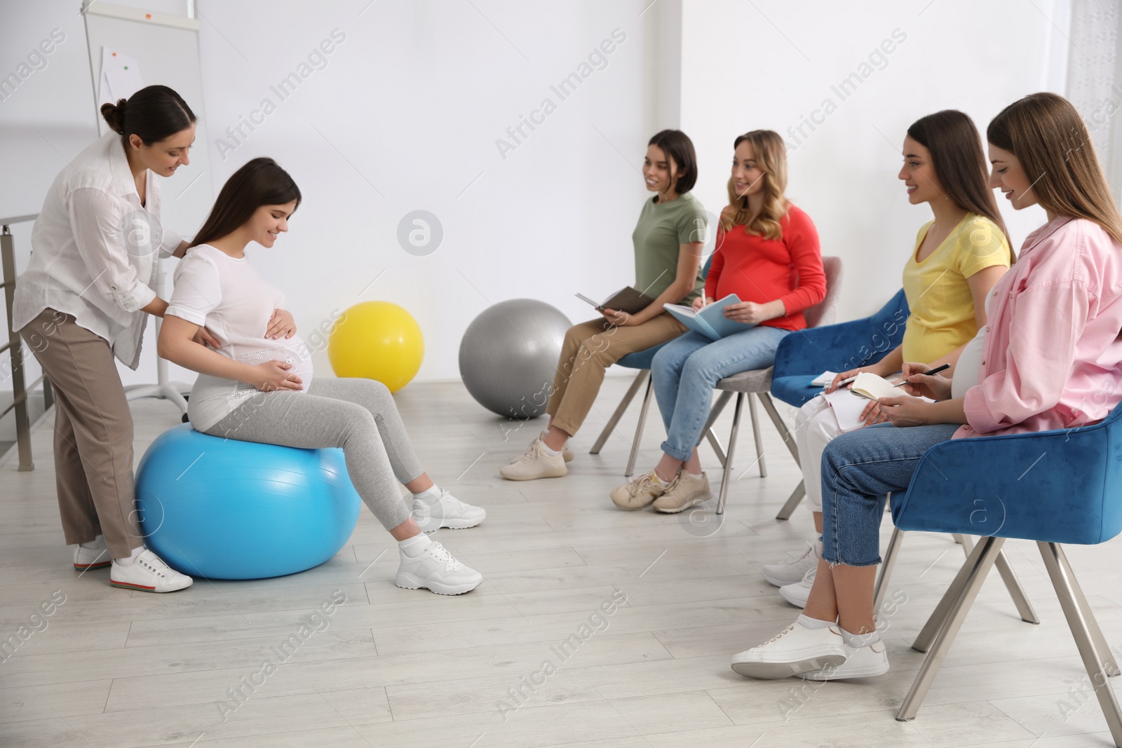 Photo of Group of pregnant women with midwife at courses for expectant mothers indoors