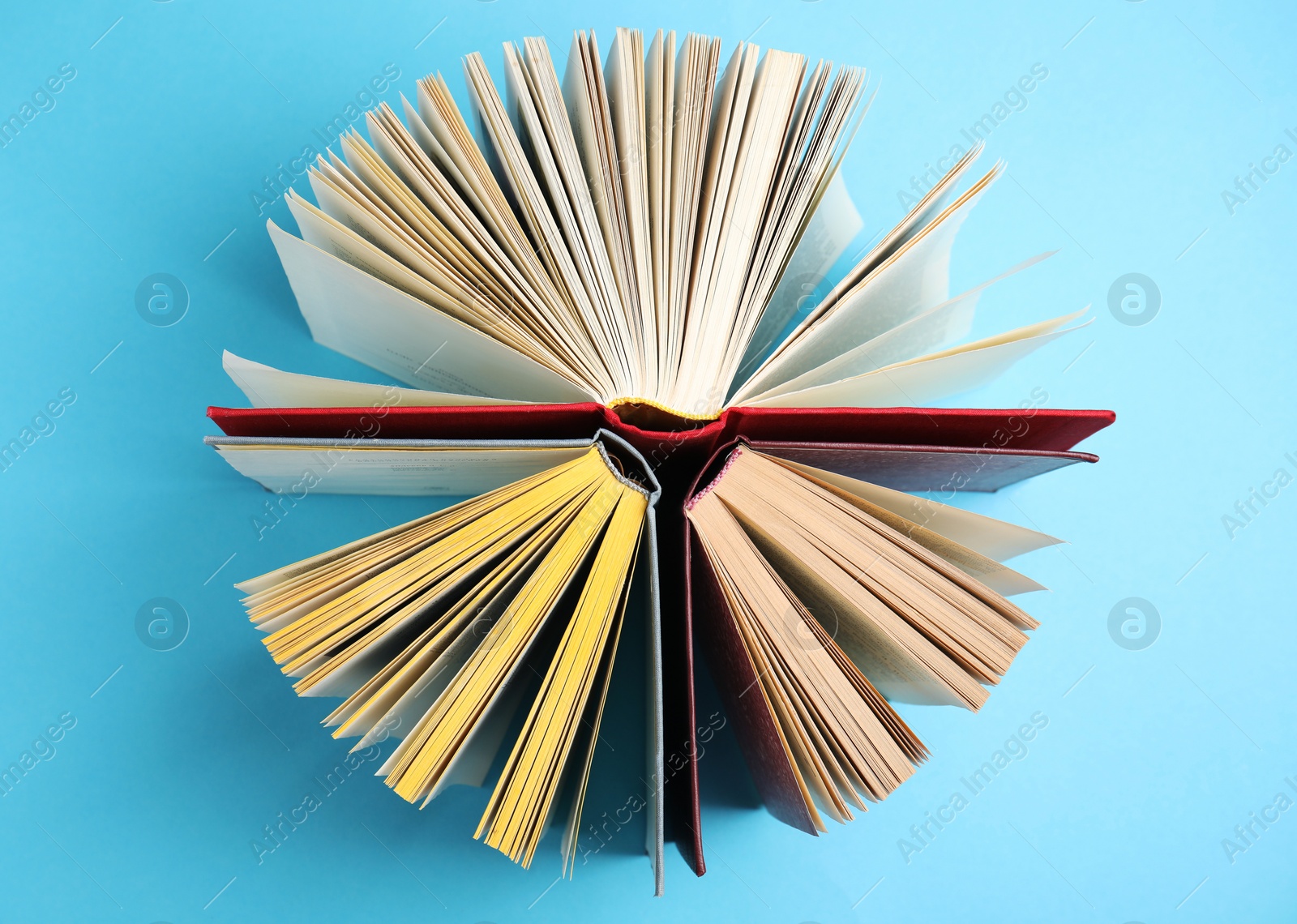 Photo of Circle made of hardcover books on light blue background, flat lay