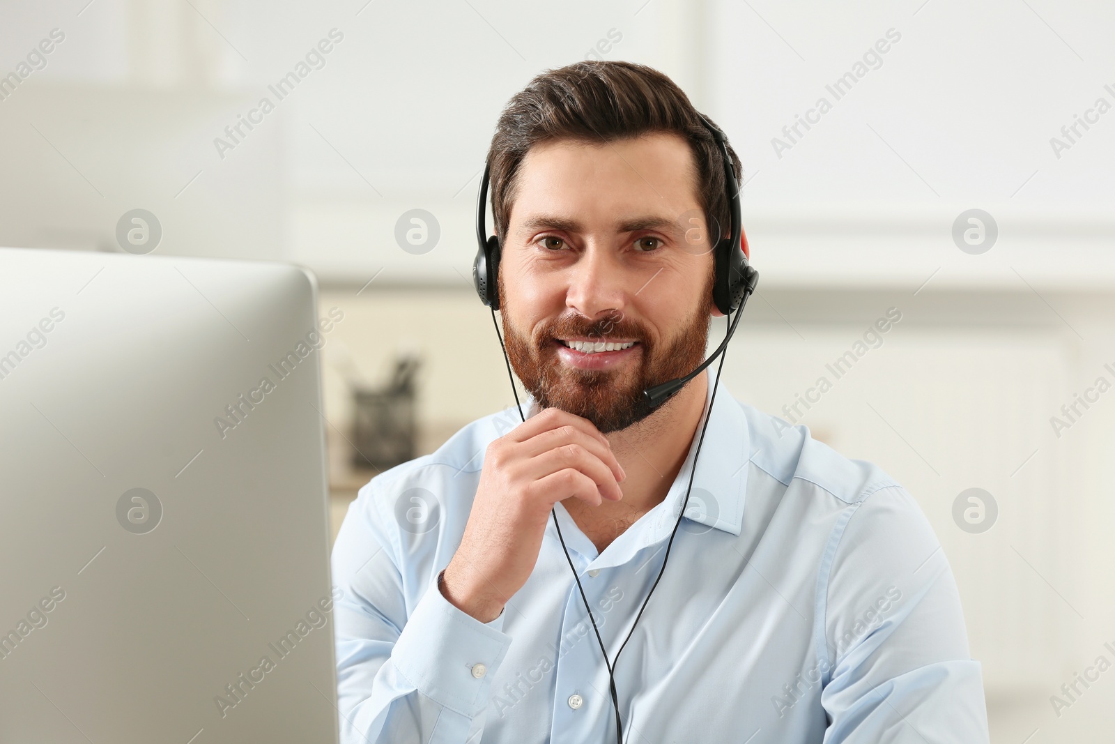 Photo of Hotline operator with headset working in office