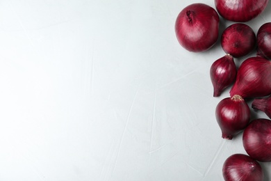 Photo of Ripe red onions on grey table, top view with space for text