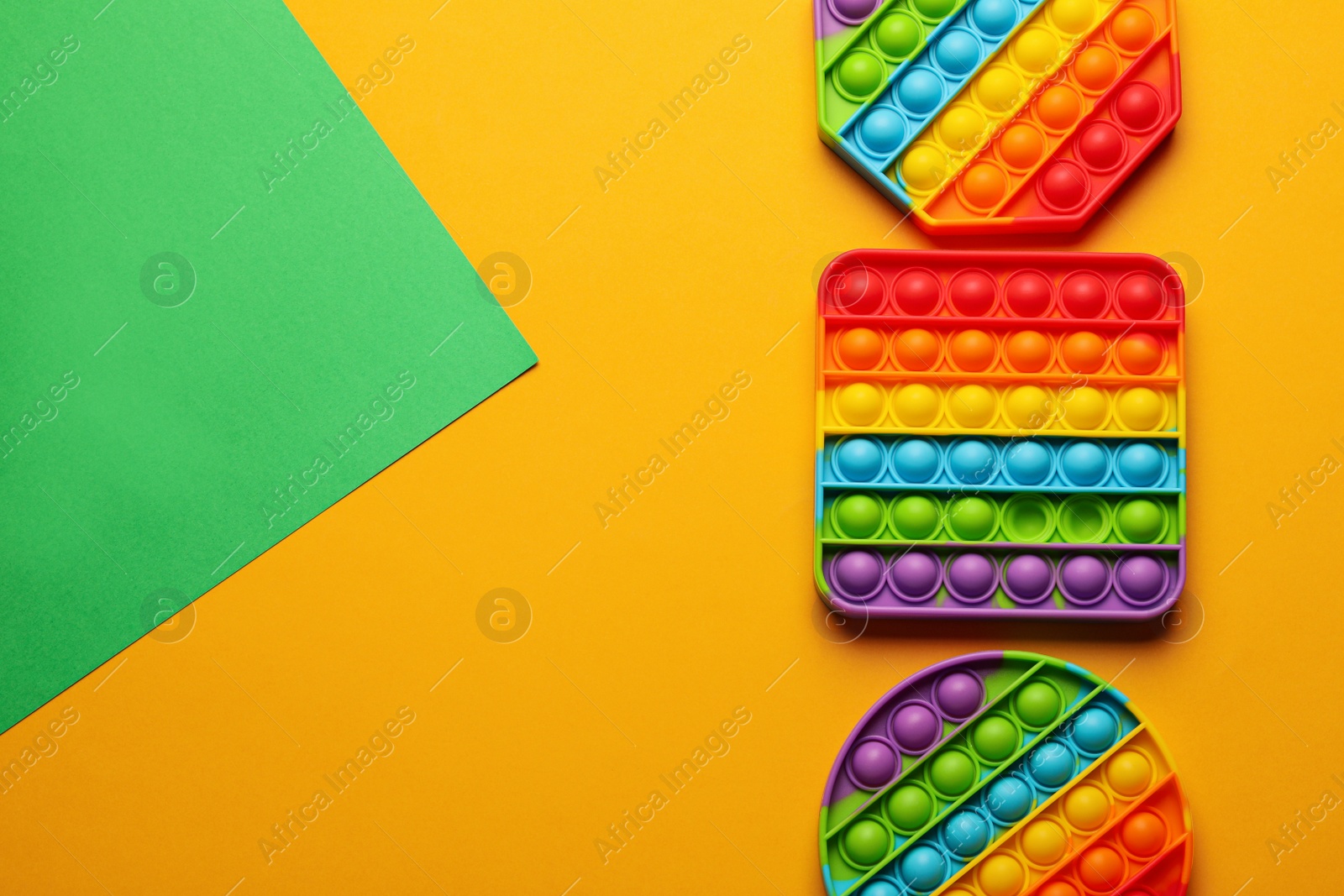 Photo of Rainbow pop it fidget toys on color background, flat lay. Space for text