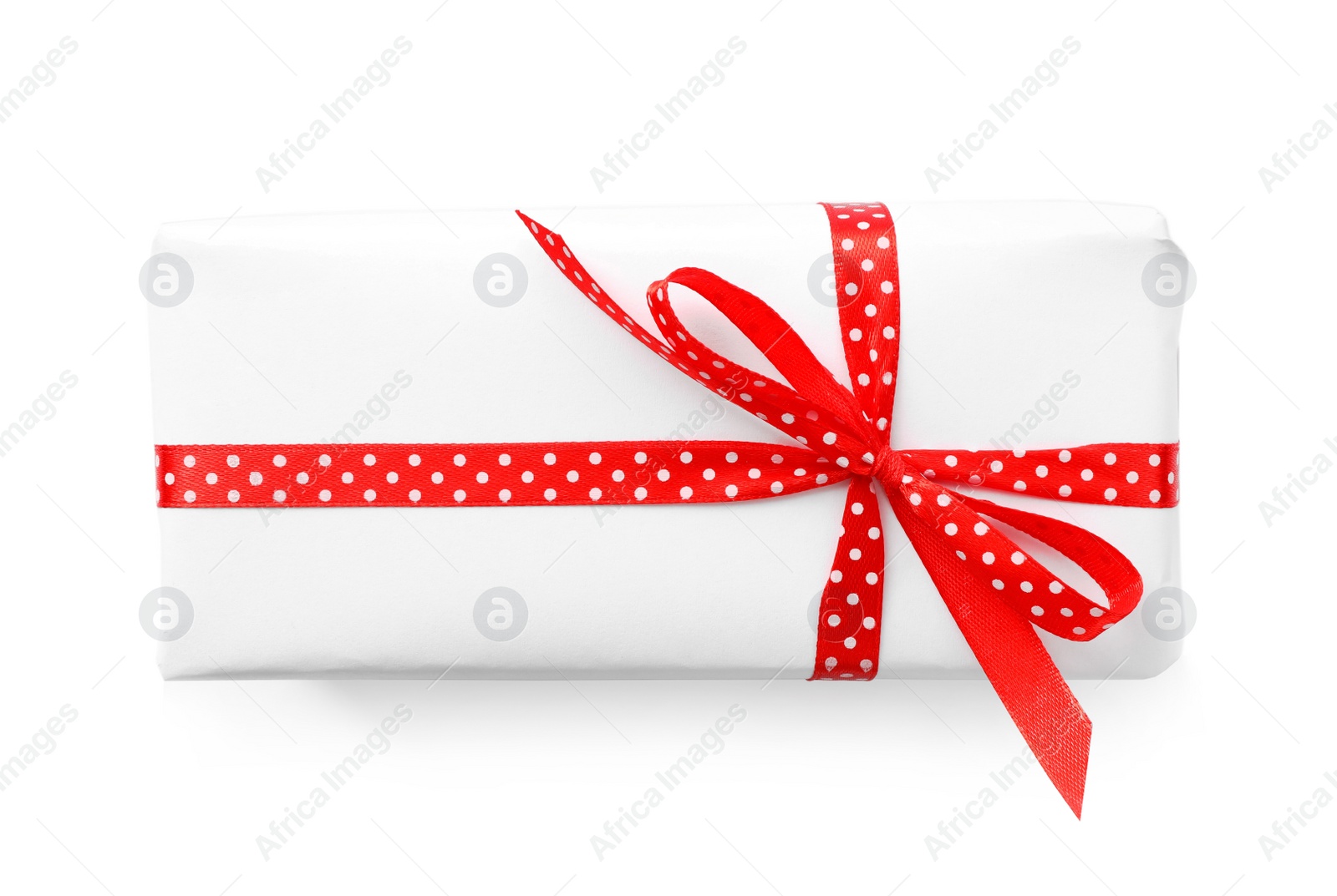 Photo of Christmas gift box decorated with red bow isolated on white, top view