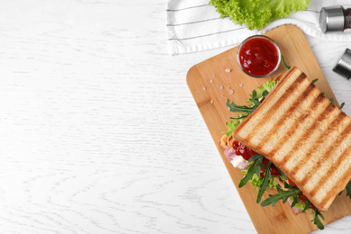 Photo of Tasty sandwich served on white wooden table, flat lay. Space for text