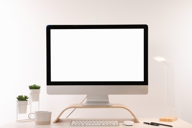 Photo of Comfortable workplace with blank computer display on desk against white background. Space for text