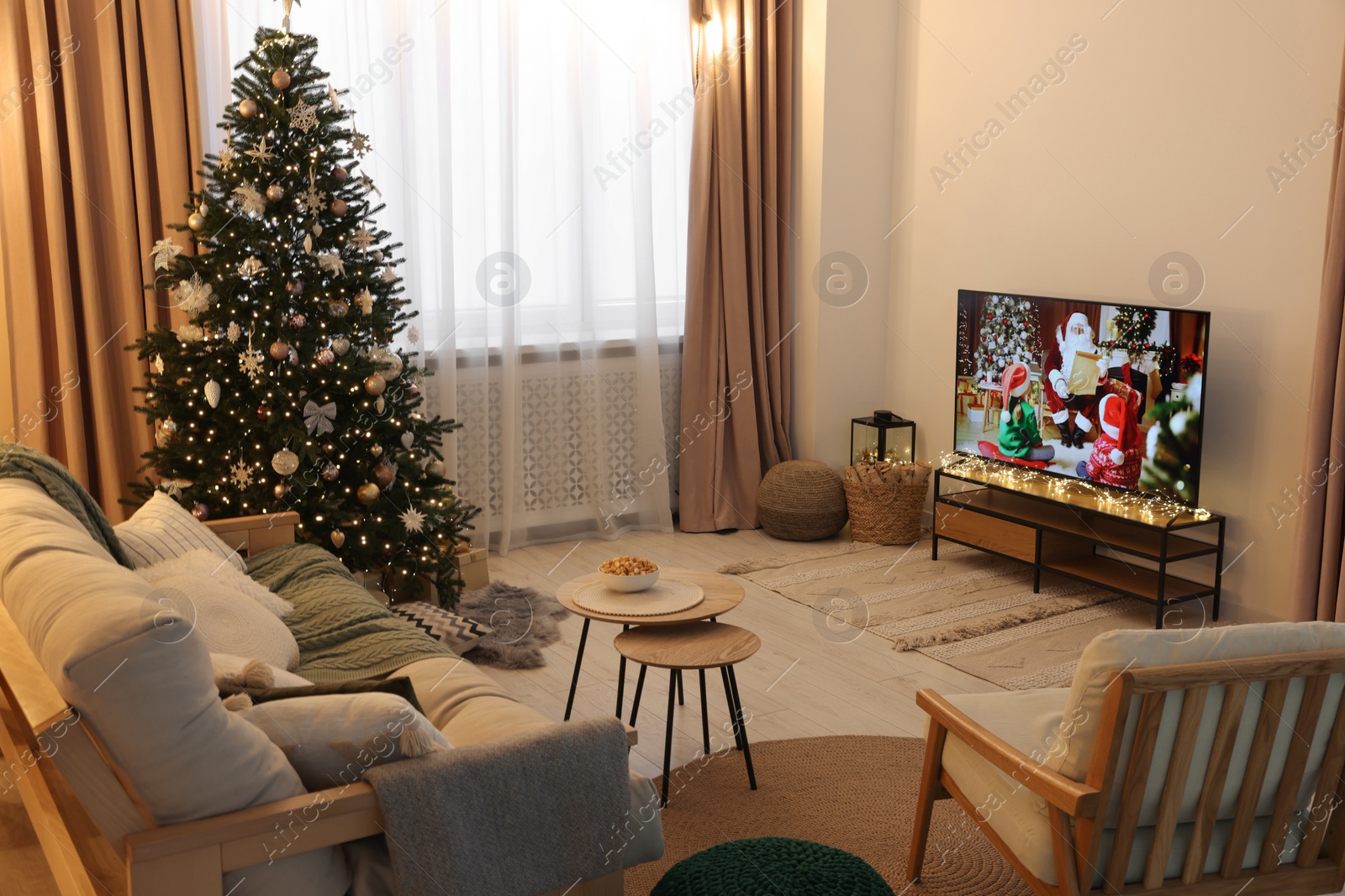 Photo of Wide TV set, furniture and Christmas tree in stylish room