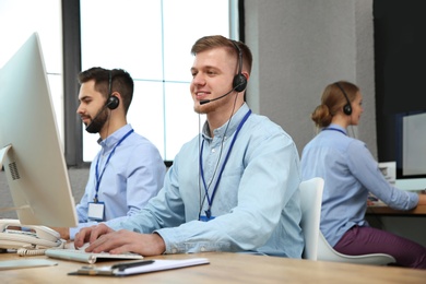 Technical support operator working with colleagues in office