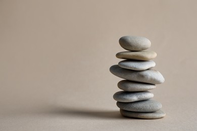 Photo of Stack of stones on beige background, space for text. Harmony and balance concept