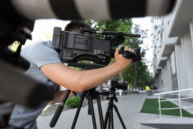 Professional video camera operator working on city street