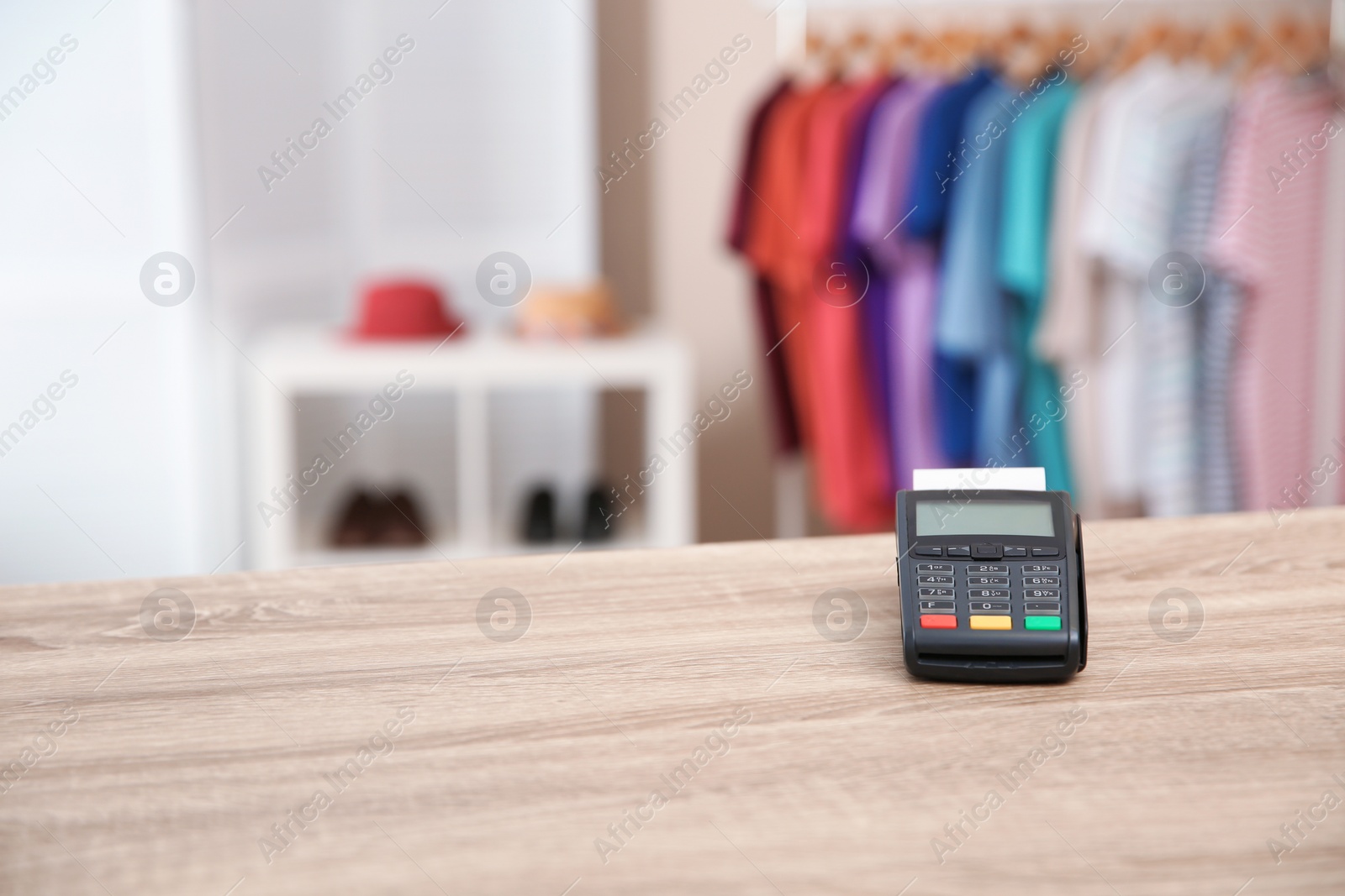 Photo of Payment terminal on counter in shop. Space for text