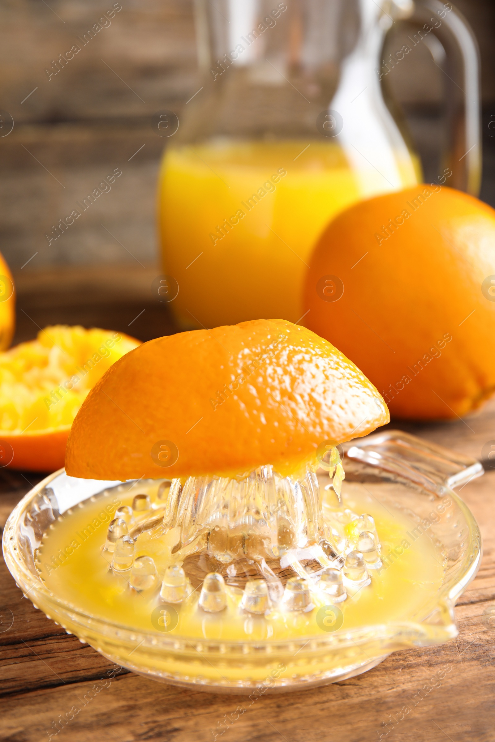 Photo of Cut fresh ripe orange and squeezer on wooden table