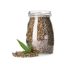 Photo of Jar with hemp seeds and green leaf on white background