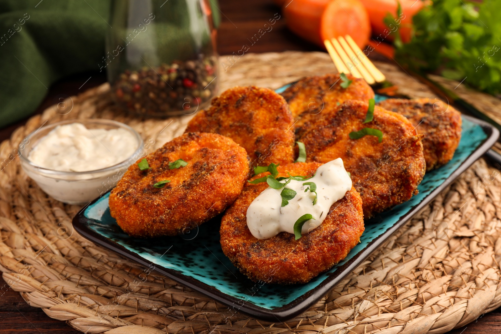 Photo of Tasty vegan cutlets served with sauce on wicker mat, closeup