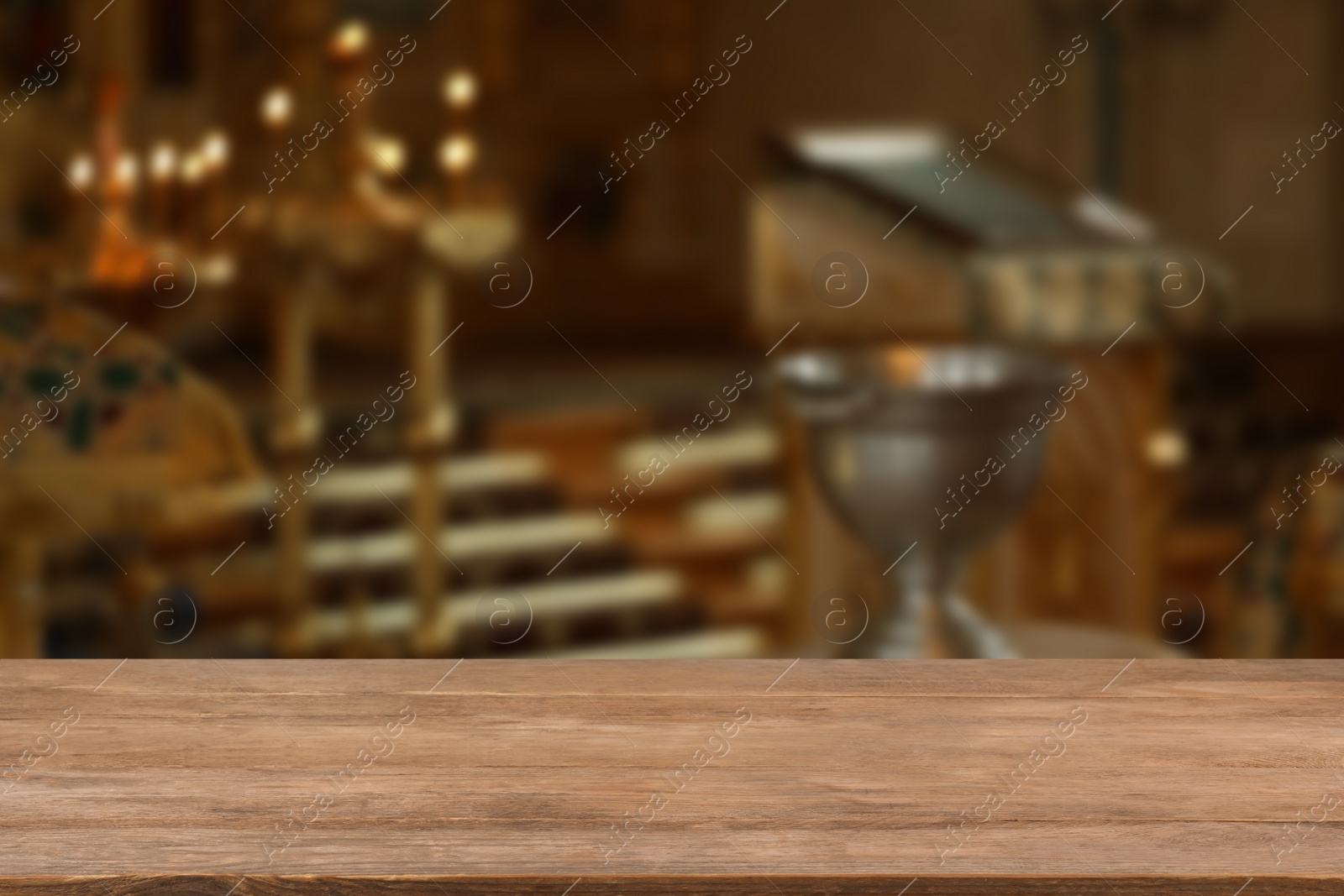 Image of Empty wooden table and blurred view of beautiful church interior, space for text