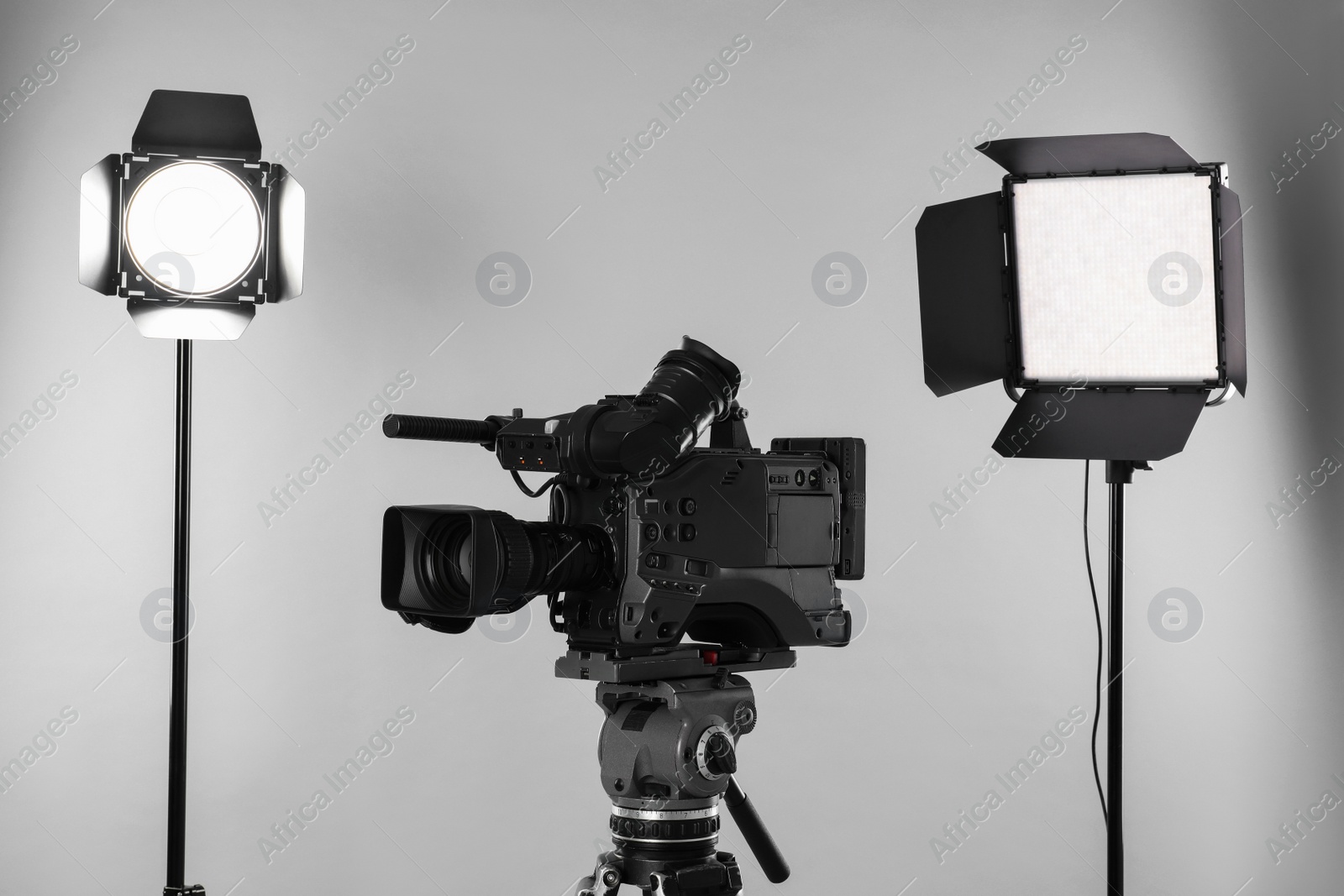 Photo of Professional video camera and lighting equipment on white background