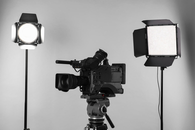 Photo of Professional video camera and lighting equipment on white background