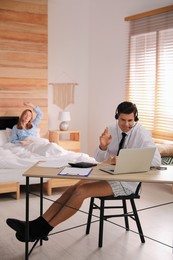 Photo of Man working on laptop in bedroom. Stay at home concept