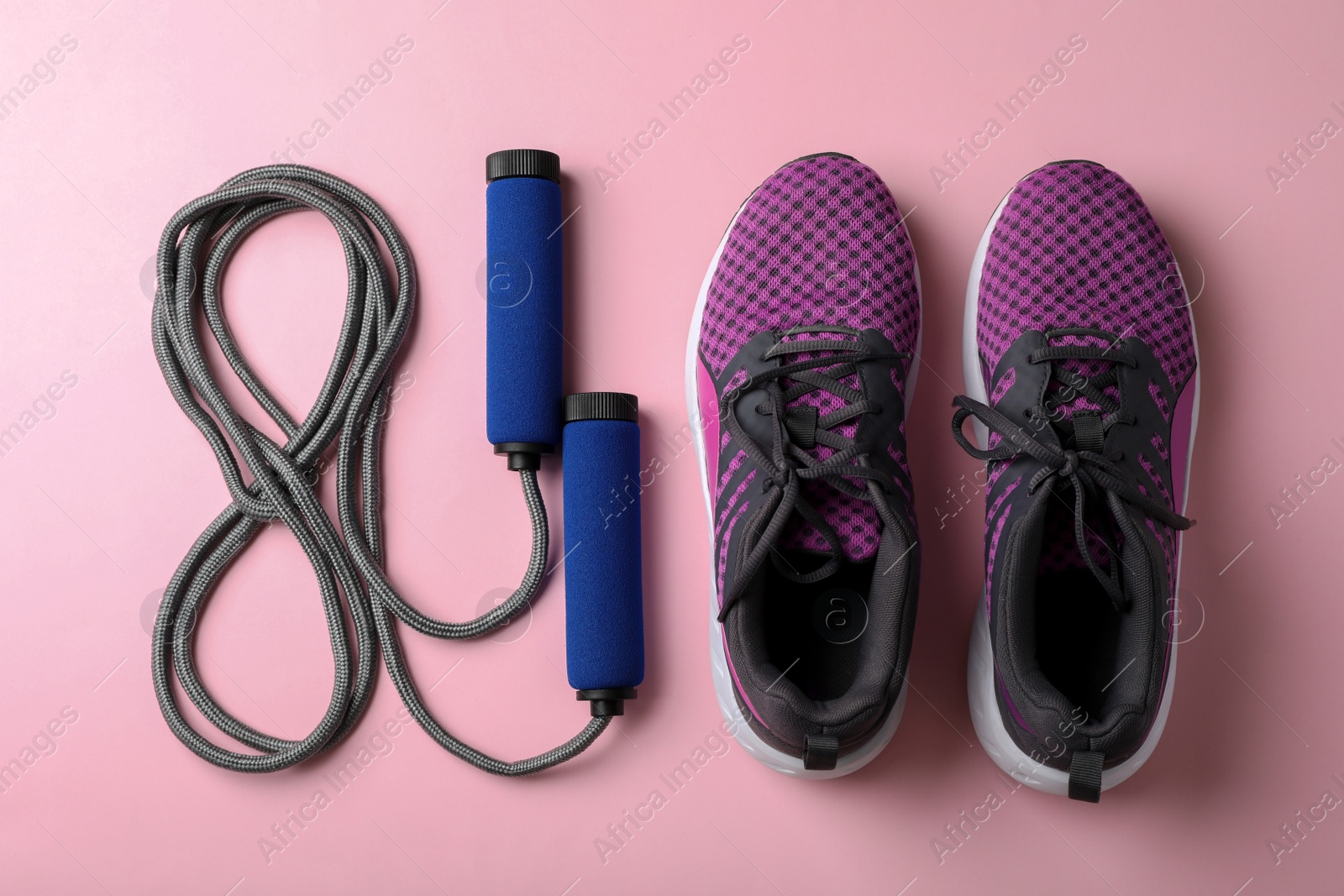 Photo of Jump rope and sneakers on color background. Healthy lifestyle