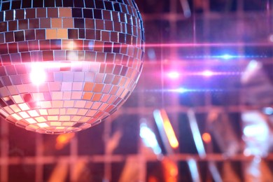 Photo of Shiny disco ball on blurred background, space for text