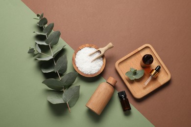 Photo of Aromatherapy products. Bottles of essential oil, sea salt and eucalyptus leaves on color background, flat lay