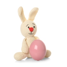 Cute Easter bunny toy and dyed egg on white background