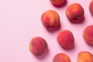 Photo of Many whole fresh ripe peaches on pink background, flat lay. Space for text