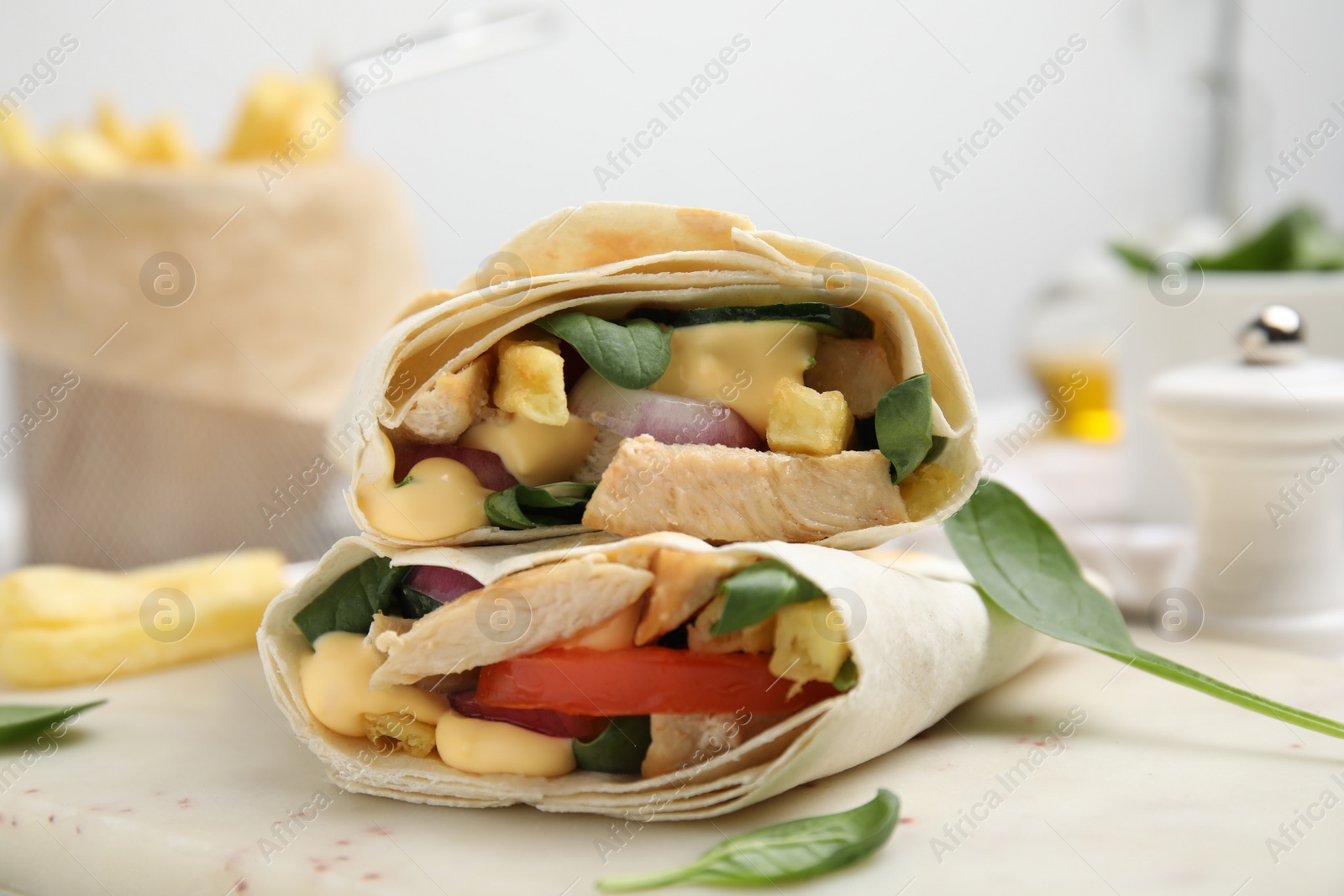 Photo of Delicious shawarmas with chicken and fresh vegetables on white table, closeup