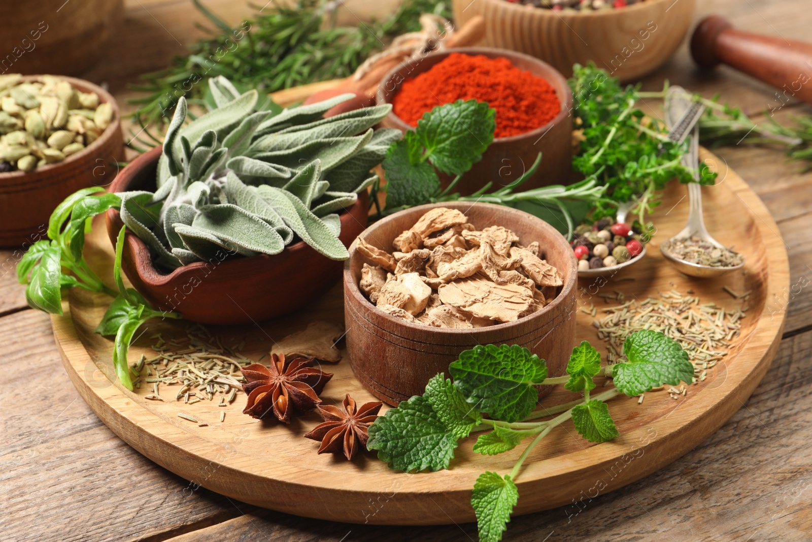 Photo of Different herbs and spices on wooden table, closeup