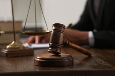 Photo of Law and justice. Closeup of judge working at wooden table, focus on gavel