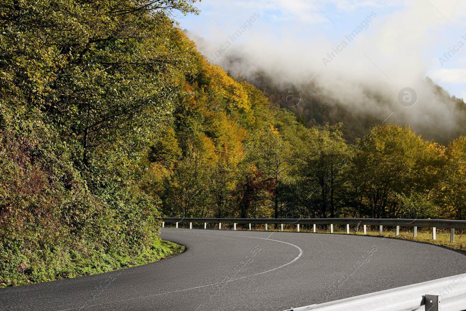 Photo of Picturesque view of empty road near trees in mountains