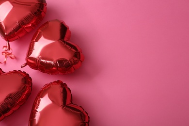 Photo of Red heart shaped balloons on pink background, flat lay with space for text. Saint Valentine's day celebration