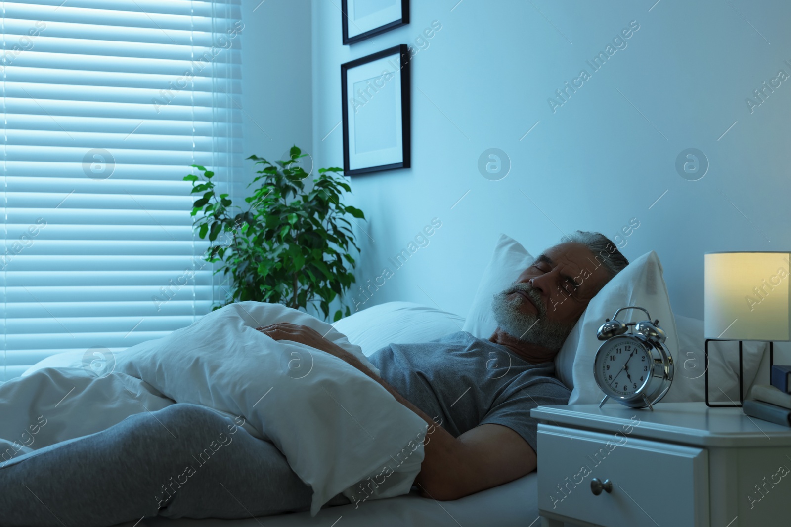 Photo of Senior man sleeping in bed at home