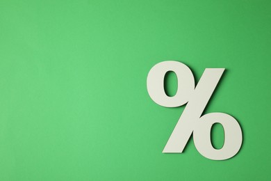 Photo of Wooden percent sign on green background, top view