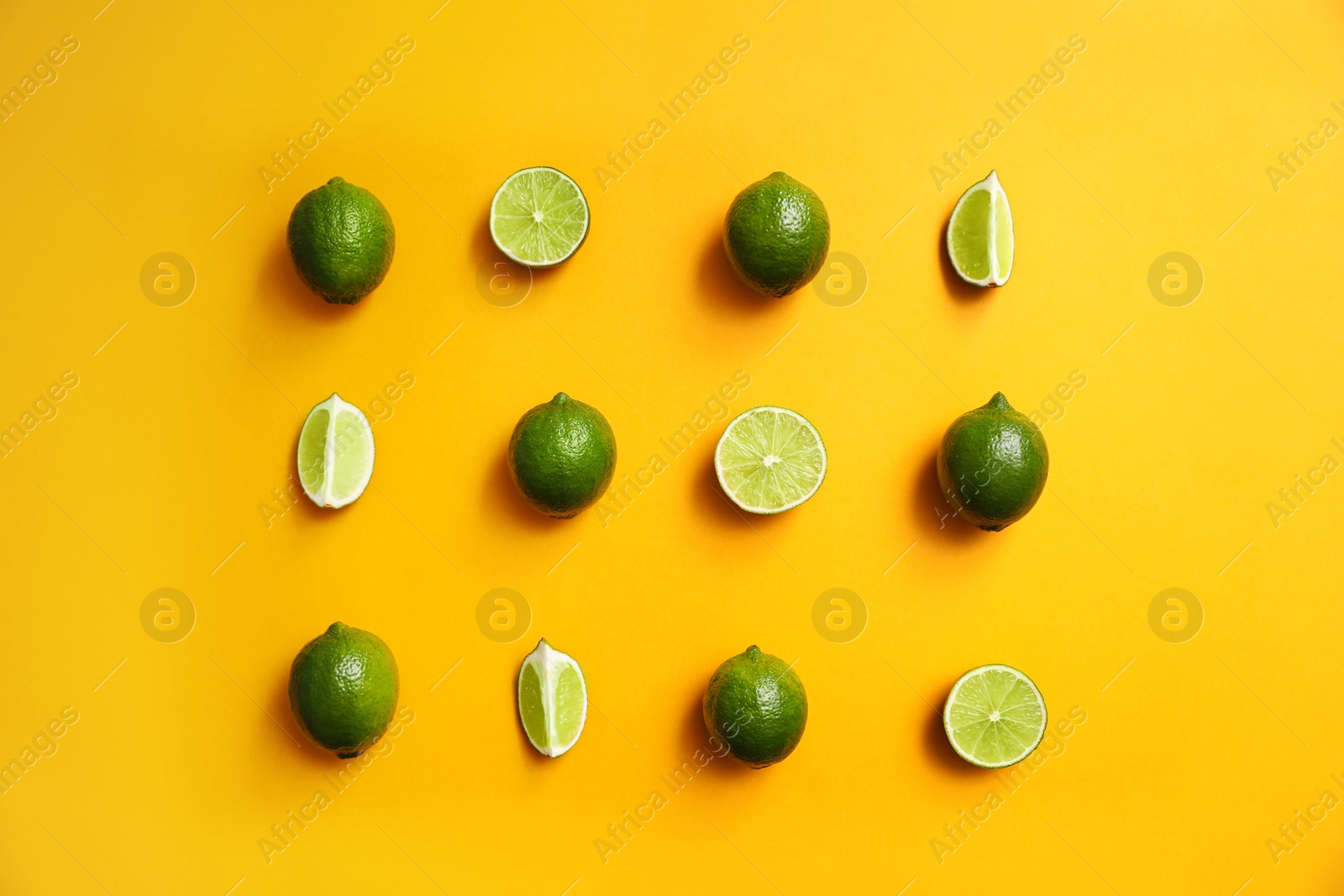 Photo of Flat lay composition with fresh juicy limes on yellow background