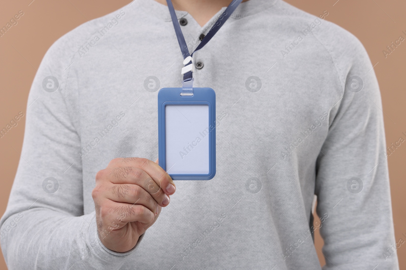 Photo of Man with blank badge on beige background, closeup