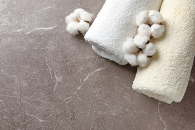 Photo of Composition with cotton flowers and towels on grey background, top view