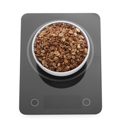 Photo of Modern kitchen scale with bowl of tasty granola isolated on white