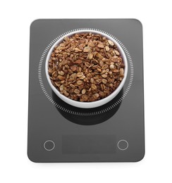 Modern kitchen scale with bowl of tasty granola isolated on white