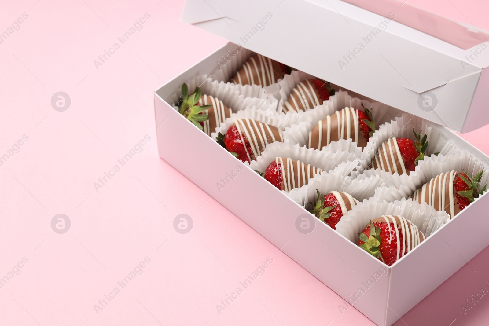 Photo of Box with delicious chocolate covered strawberries on pink background. Space for text