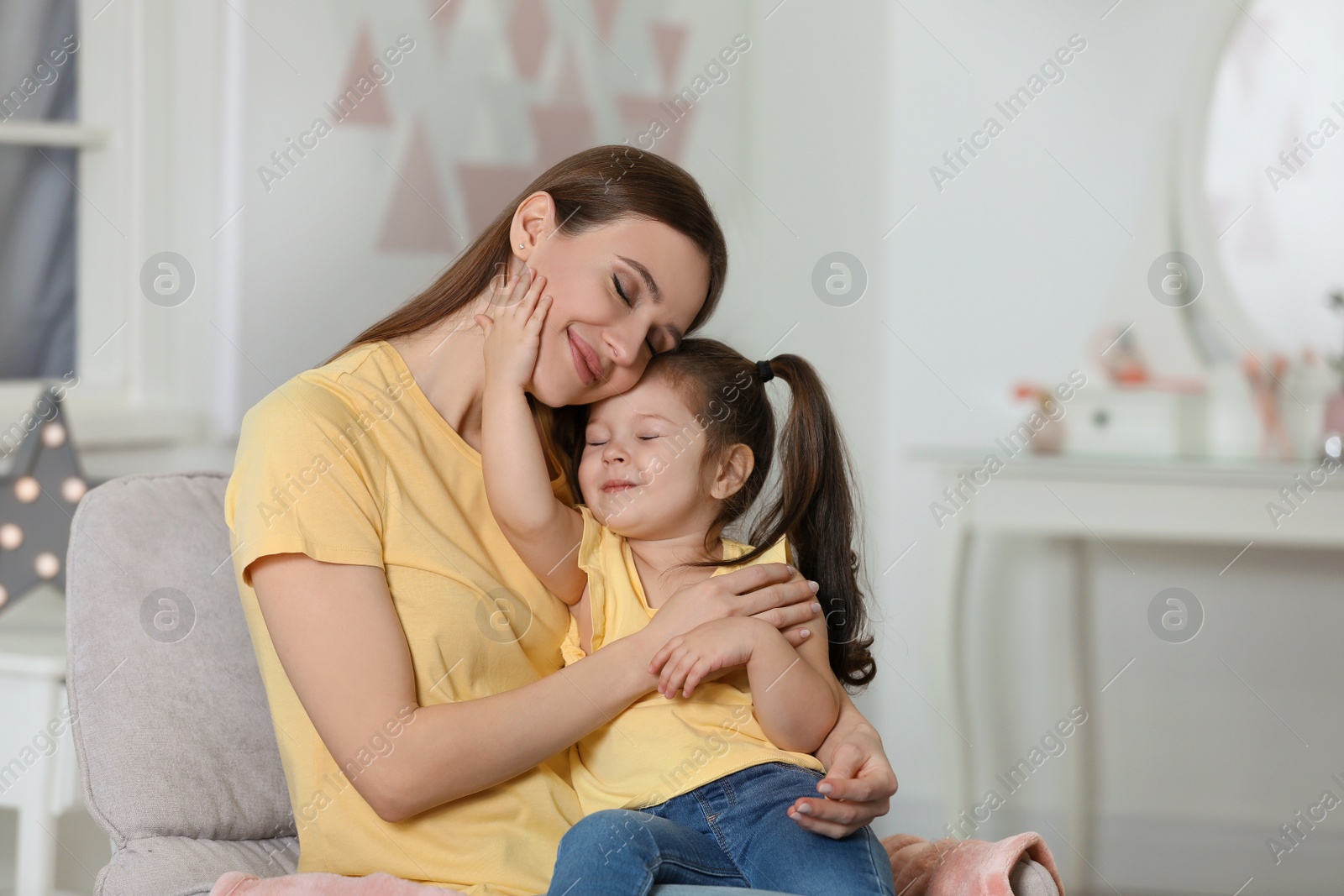 Photo of Young mother with little daughter at home