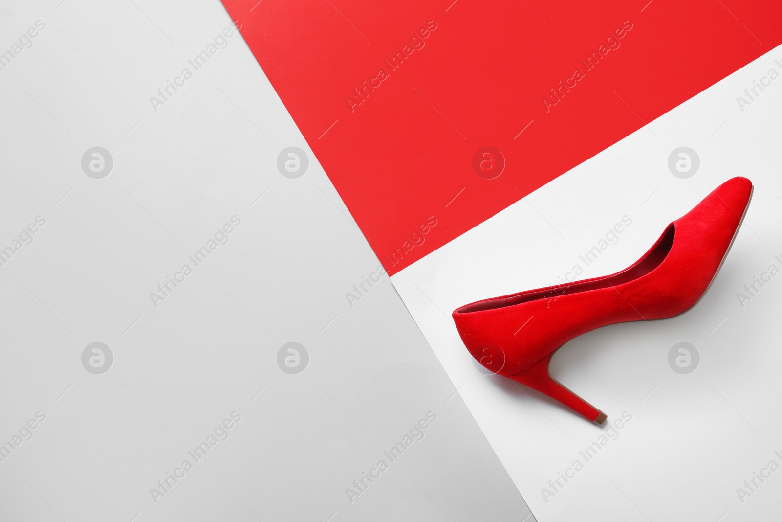 Photo of Stylish high heel shoe on color background, top view with space for text