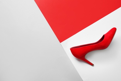 Stylish high heel shoe on color background, top view with space for text