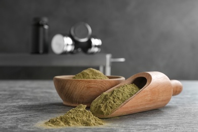 Photo of Bowl and scoop with hemp protein powder on table. Space for text