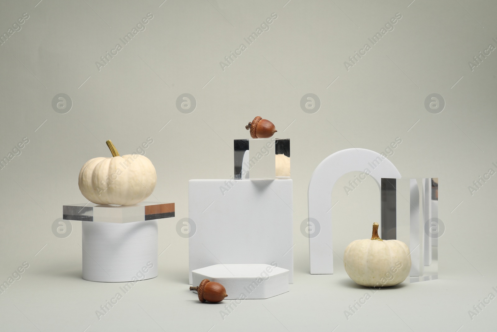 Photo of Autumn presentation for product. Geometric figures, pumpkins and acorns on light grey background