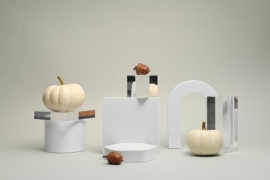 Photo of Autumn presentation for product. Geometric figures, pumpkins and acorns on light grey background