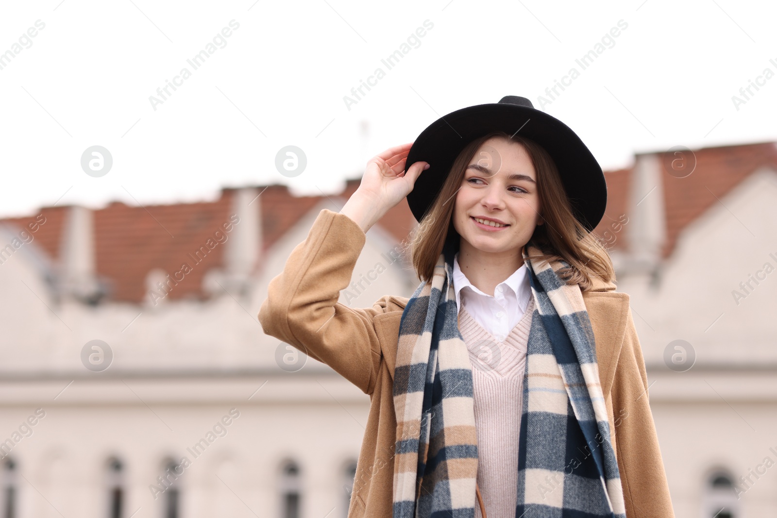 Photo of Beautiful woman in warm scarf and hat outdoors, space for text