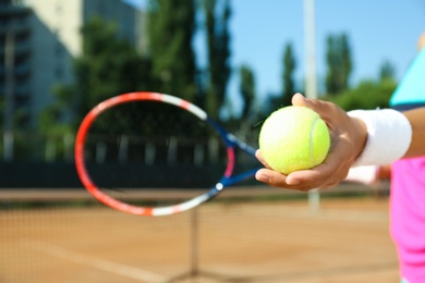 Photo of Sportswoman preparing to serve tennis ball at court, closeup