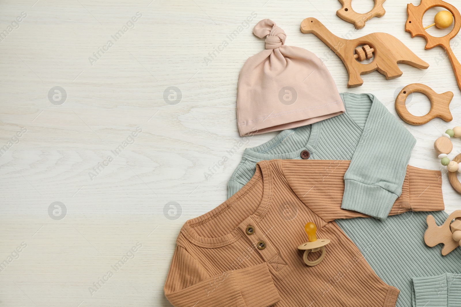 Photo of Flat lay composition with baby clothes and accessories on white wooden background, space for text