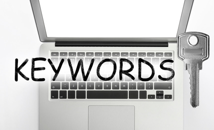 Image of Word Keywords, laptop and key on white background, top view. SEO direction
